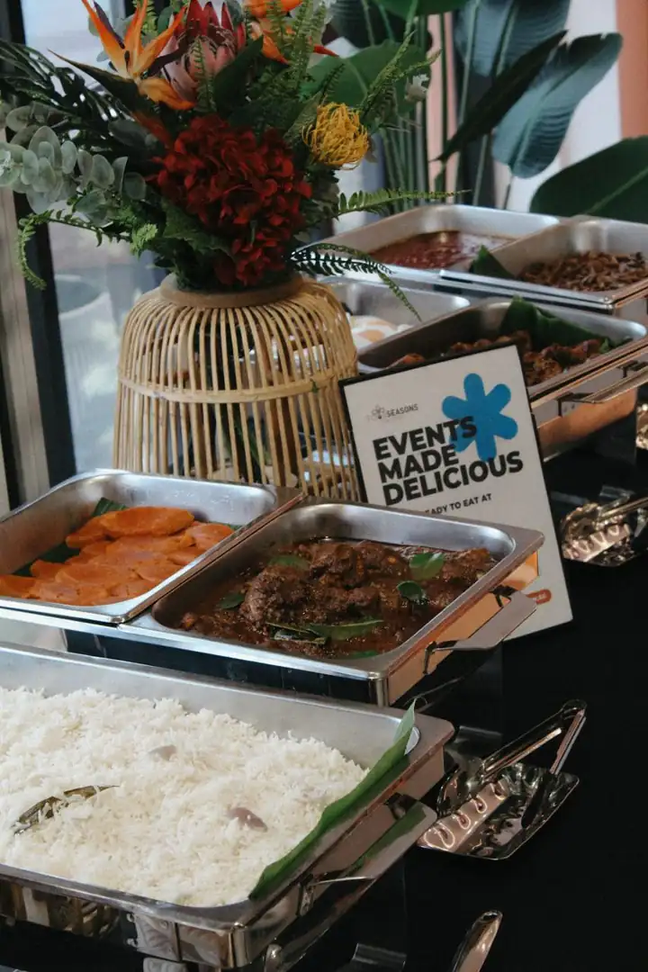 Four Seasons Catering buffet spread with rendang, rice and floral styling, halal caterer in Singapore since 1994